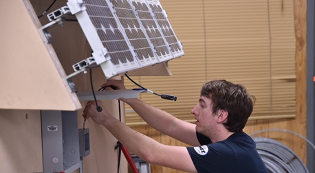 Student in KCC solar lab learning hands-on about solar energy.