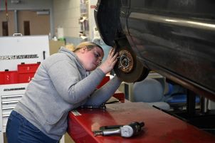 Automotive student fixing up her vehicle.
