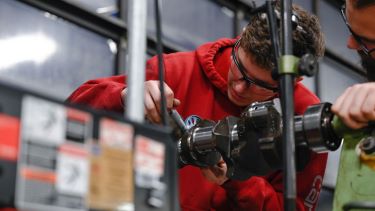 Automotive student working through a vehicle part