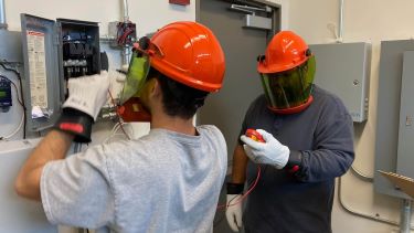 Two technician students dealing with an outlet