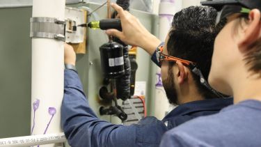 Air conditioning students working through an electrical circuit