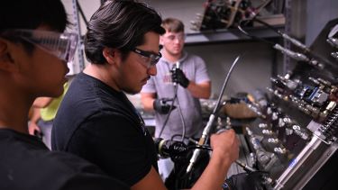 Three students ensuring the proper function of the output/input technology system