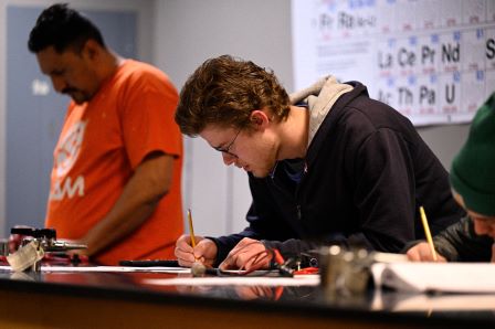 A student doing a worksheet in a Chemistry classroom. 