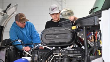 Students examining diesel components for notes