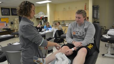 Physical therapist professor demonstrating a lesson in class