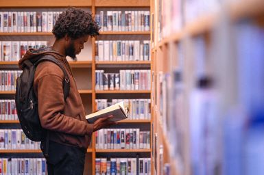 Student in library reading a history book.