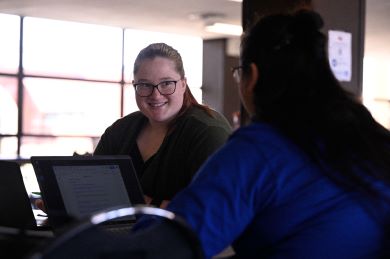 Two students sitting down at a table in the college center at KCC. 